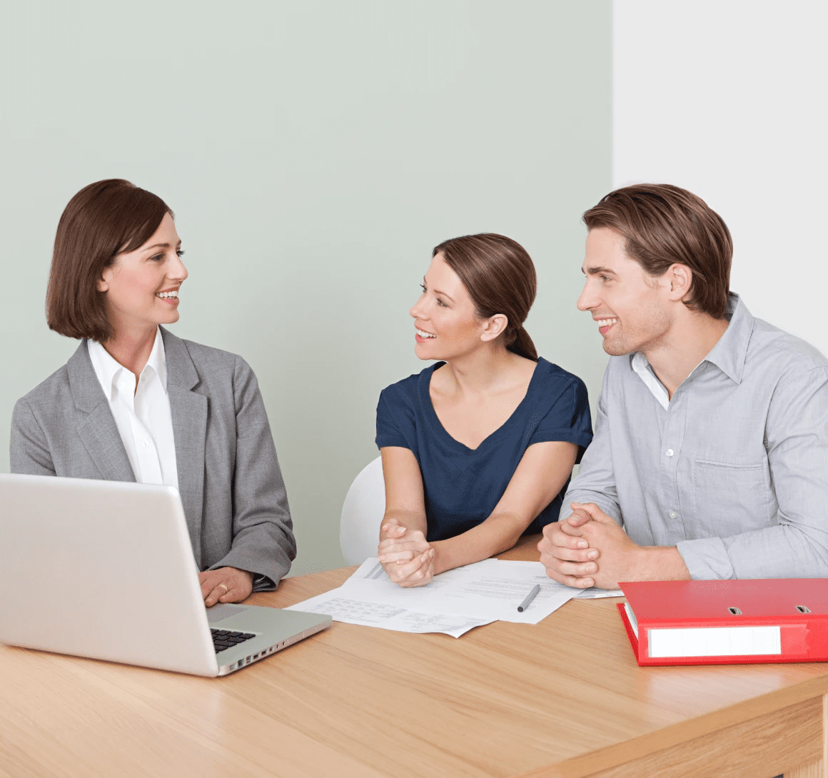 Couple consulting financial advisor at office desk